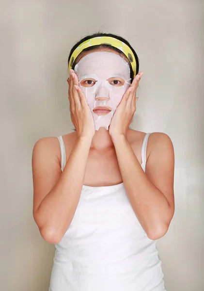 Retrato de bela jovem aplicando máscara facial rejuvenescimento em seu rosto — Fotografia de Stock