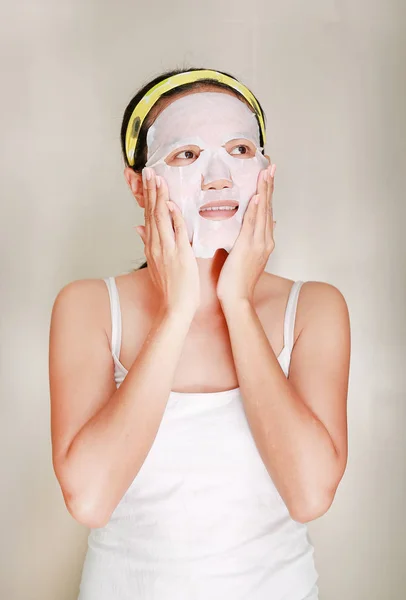 Retrato de bela jovem aplicando máscara facial rejuvenescimento em seu rosto — Fotografia de Stock