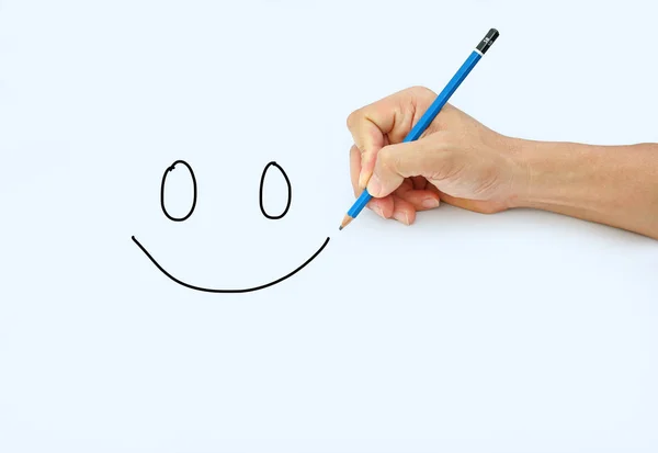 Kezében egy ceruzával egy fehér papír alapon ceruzával kép mosoly — Stock Fotó