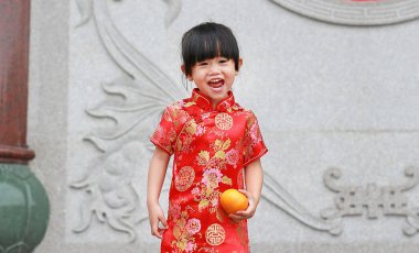 Bangkok Tayland Çin tapınağında kutsal turuncu holding ile elbise şirin Asyalı çocuk kız geleneksel Çince.