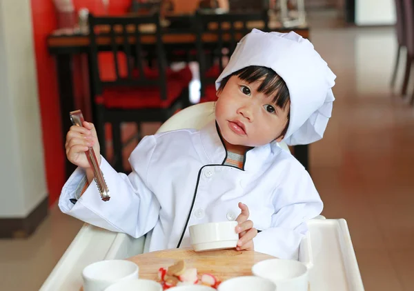 Kid flicka i en kostym av den lilla kocken göra mini pizza, Matlagning barn koncept. — Stockfoto
