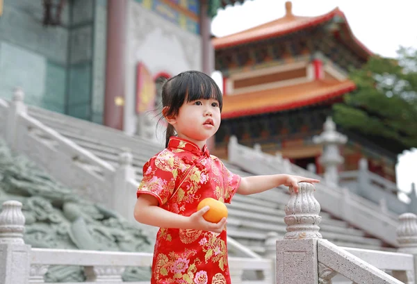 Schattige Aziatische jongen meisje in traditionele Chinese jurk met houden van Heilige oranje op chinese tempel in bangkok thailand. — Stockfoto