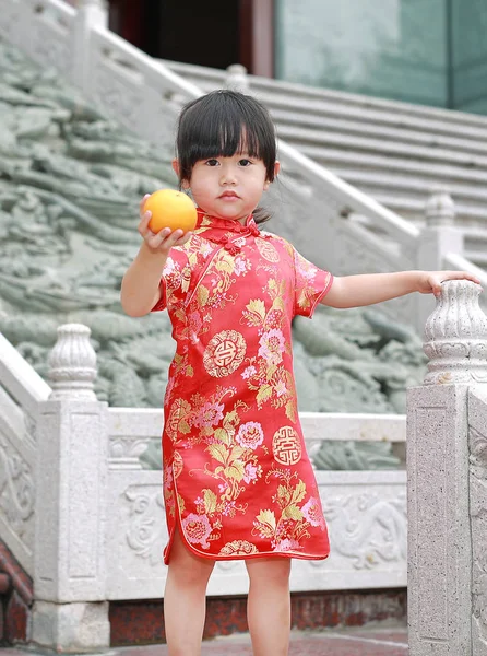 Cute asian dziecko dziewczynka w języku chińskim tradycyjnym sukienka z gospodarstwa święte Orange w chińskiej świątyni w bangkok Tajlandia. — Zdjęcie stockowe