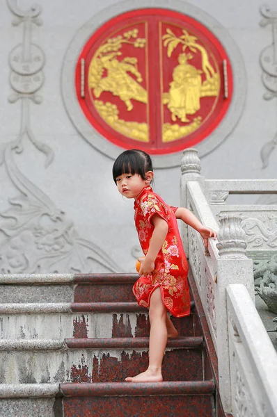 Cute asian kid girl in Traditional Chinese dress with holding sacred Orange at chinese temple in bangkok thailand. — Stock Photo, Image