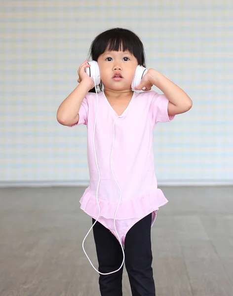 Malá dívka poslech hudby se sluchátky — Stock fotografie