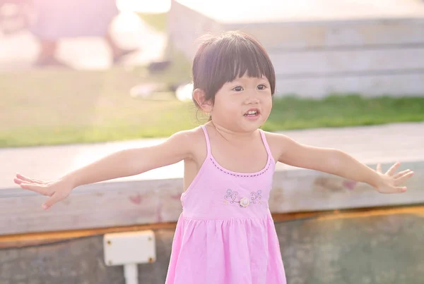 Porträt eines Mädchens mit natürlichen Emotionen, das im öffentlichen Garten am Meer lächelt — Stockfoto