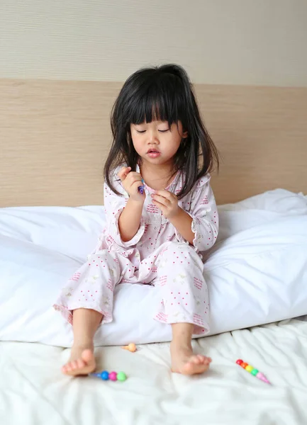 Μικρό παιδί κορίτσι Παίξτε και να μάθουν το μαγικό χρώμα στο κρεβάτι το πρωί. — Φωτογραφία Αρχείου