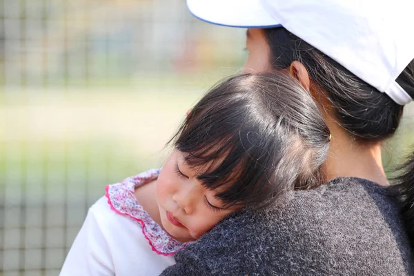 Ibu membawa anak gadis tidur dalam pelukannya . — Stok Foto