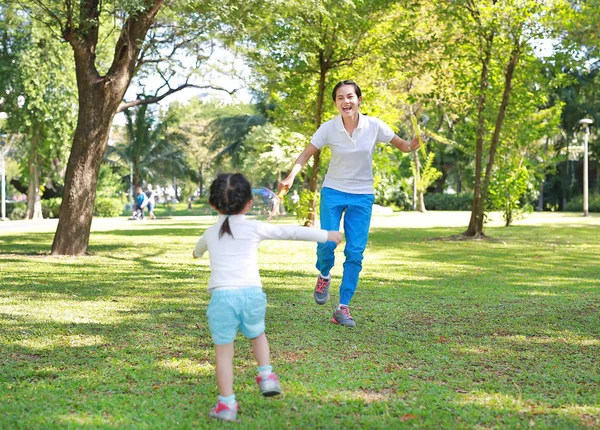 Aranyos kis lány és anya játék buborék a parkban. — Stock Fotó