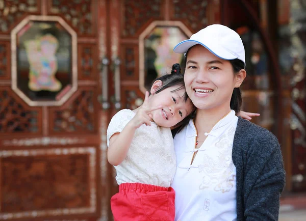 Portret van de moeder en dochter knuffelen op bangkok chinatown, mooi meisje haar moeder buiten knuffelen. — Stockfoto