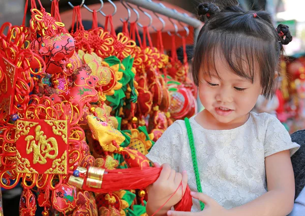 Niña en vestido chino contra las decoraciones rojas chinas tradicionales son muy populares durante el Festival de Año Nuevo Chino en Chinatown en Bangkok, Tailandia . — Foto de Stock