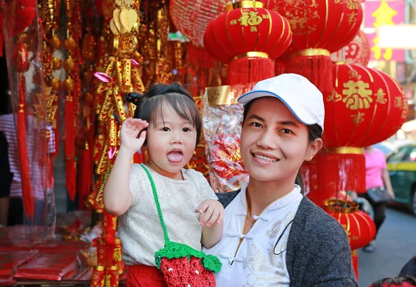 Ázsiai nő és a lánya, a kínai ruha hagyományos kínai piros díszek ellen igen népszerűek során a kínai újév fesztivál a kínai negyed, bangkok, Thaiföld. — Stock Fotó