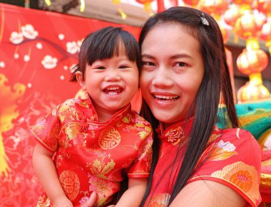 Mutlu Çin yeni yılı, şirin Asyalı kız gülümseme ve çocuğunu geleneği içinde Çince elbise sarılmak