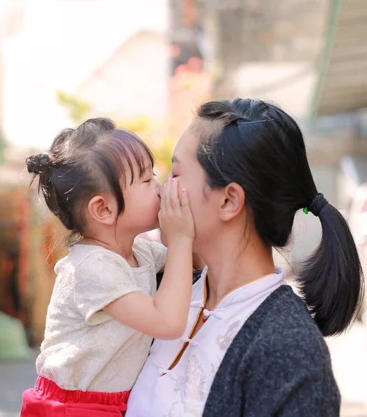 Gelukkig liefdevolle familie, moeder en kind meisje kussen. — Stockfoto