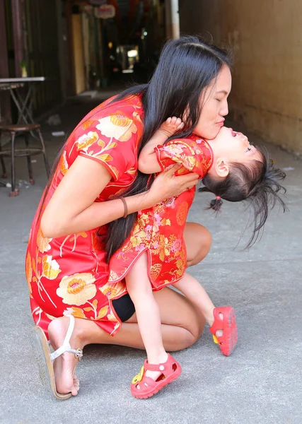 Happy Chinese Nieuwjaar, leuke Aziatische meisje glimlach en knuffel van haar kind In traditie Chinese jurk — Stockfoto