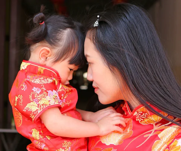 Happy Chinese Nieuwjaar, leuke Aziatische meisje glimlach en knuffel van haar kind In traditie Chinese jurk — Stockfoto