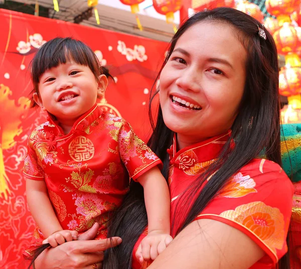 Happy Chinese new year, Cute Asian Girl smile and hug her child In Tradition Chinese dress