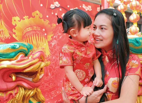 Happy Chinese new year, Cute Asian Girl smile and hug her child In Tradition Chinese dress