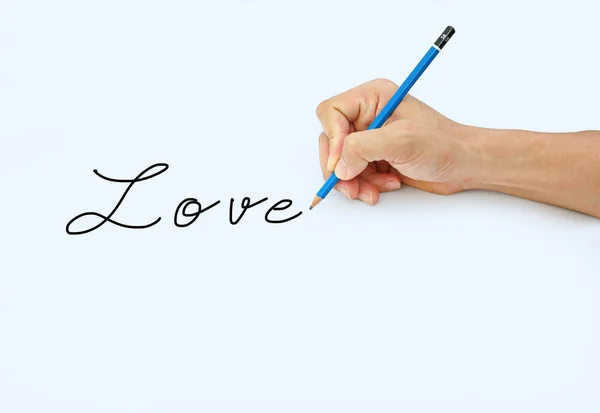 Mano sosteniendo un lápiz sobre un fondo de papel blanco, escribiendo con lápiz por palabra "Amor  " — Foto de Stock