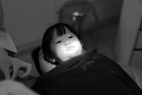 Menina durante a extração dentária, tom preto e branco — Fotografia de Stock