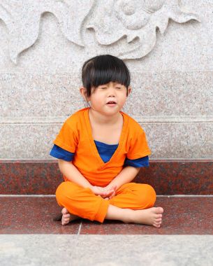 Çin tapınak Tayland, Çin yeni yılı konsept ifadede meditasyon yapıyor Shaolin keşiş turuncu giysileri çocuk kızı.