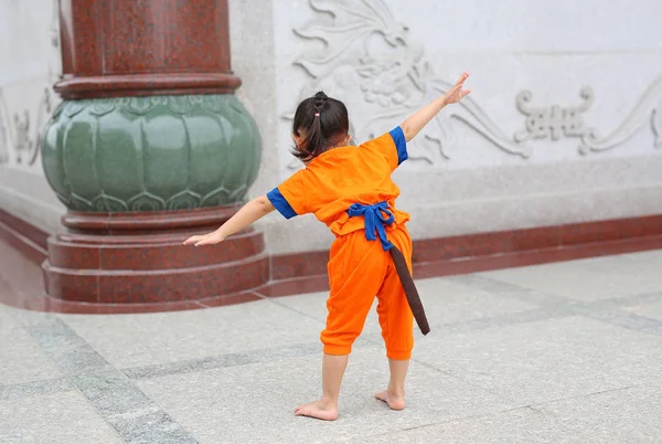 Dziecko dziewczynka w Shaolin mnich pomarańczowy ubrania robi medytacji wyrażenie w chińskiej świątyni w Tajlandii, koncepcja chiński nowy rok. — Zdjęcie stockowe