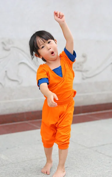 Gyerek lány Shaolin szerzetes narancssárga ruhát csinál meditáció kifejezést a kínai temple, Thaiföld, kínai új év koncepció. — Stock Fotó