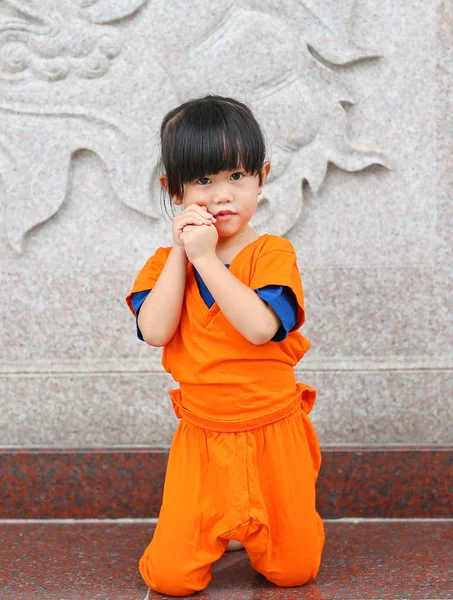 Enfant fille en Shaolin moine vêtements orange faisant expression de méditation dans le temple chinois en Thaïlande, concept de nouvelle année chinoise . — Photo