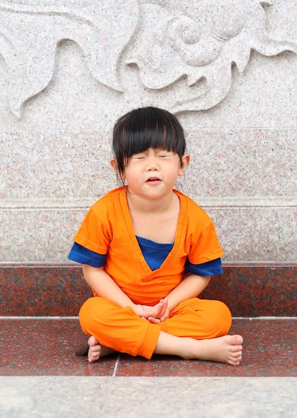 Kid girl in Shaolin monk orange clothes doing Meditation expression in chinese temple in thailand, Chinese new year concept. — Stock Photo, Image