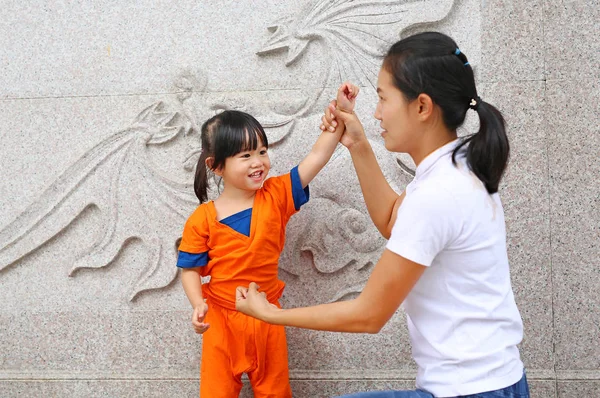 Ευτυχισμένη οικογένεια, τη μητέρα και το παιδί κορίτσι αγωνίζονται στο κινέζικο ναό. — Φωτογραφία Αρχείου