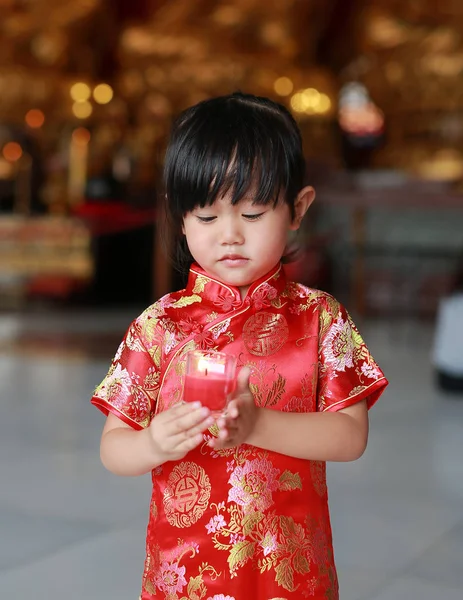 Азиатская девочка в традиционном платье зажечь свечи поклонения в китайском храме в Бангкоке, Таиланд . — стоковое фото