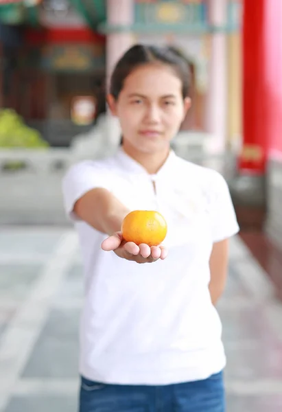 Ασιατικές γυναίκα κρατώντας Ιερά πορτοκαλί στην κινεζική ναός στην Μπανγκόκ, Ταϊλάνδη. Έννοια του κινεζικού νέου έτους. Εστίαση στο πορτοκαλί. — Φωτογραφία Αρχείου