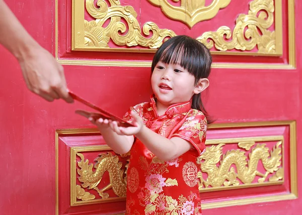 Kobieta dłoni dając czerwony pakietów pieniężnej prezent dla Cute dziewczynka o chińskiej świątyni w Bangkoku, Tajlandia. Koncepcja chiński nowy rok. — Zdjęcie stockowe