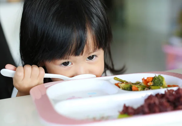 Lindo asiático chico chica edad acerca de 2 años viejo comer arroz por uno mismo — Foto de Stock