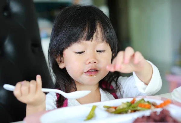 Asian child cute or kid girl enjoy eating and looking or stare grilled chicken with papaya salad for Thai food and appetizing with healthy to 5 groups on breakfast or lunch in