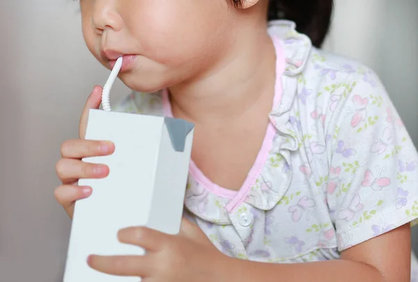 Fechar-se de menina bebendo leite com palha — Fotografia de Stock