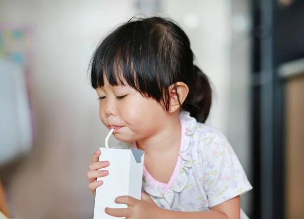Fechar-se de menina bebendo leite com palha — Fotografia de Stock