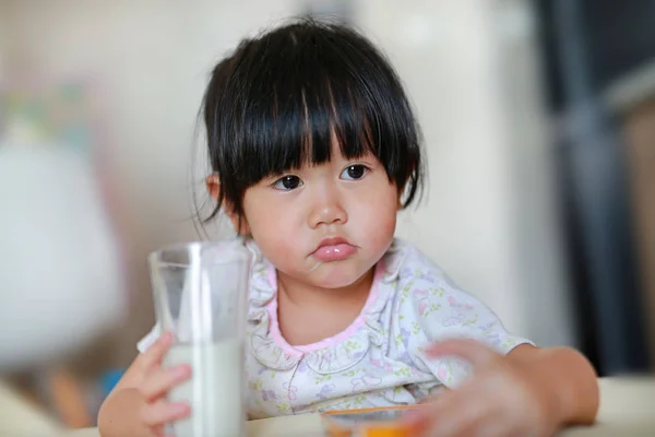 Küçük kızın sıkılmış gıda süt içmek istemiyor pijama yakın çekim. — Stok fotoğraf
