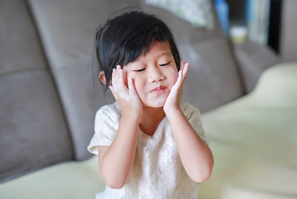 Retrato de una linda niña aplicando polvo de bebé en su cara. Concepto de Talco . —  Fotos de Stock