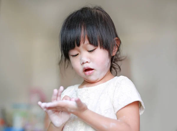 Портрет милой маленькой девочки с детским порошком на лице и руке. Концепция Talcum . — стоковое фото