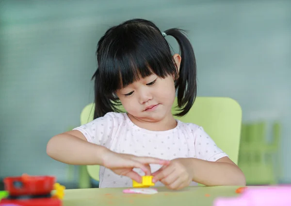 Niña en la mesa juega fruta artificial en la habitación de los niños . — Foto de Stock