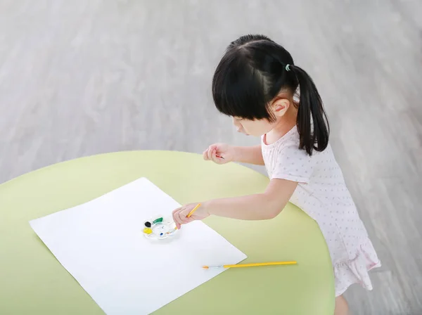 Enfant fille peinture avec pinceau et aquarelle. Concept d'activités pour enfants . — Photo