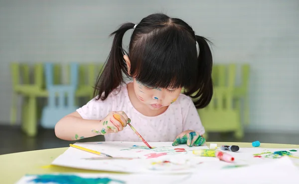 Niña pintando con pincel y acuarelas. Concepto de actividades infantiles . — Foto de Stock