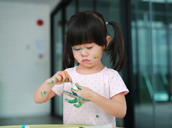 Παιδί κορίτσι ζωγραφική με το πινέλο και νερό χρώματα. Παιδί δραστηριότητες έννοια. — Φωτογραφία Αρχείου