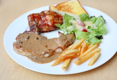 Izgara domuz eti ve sebze plaka ahşap arka plan üzerinde.