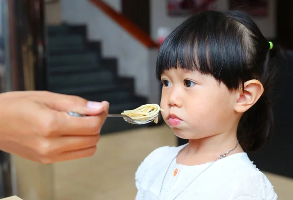 Küçük çocuk kız sıkıcı yemek yeme. Çocuk kız gıda ile sıkılmış.