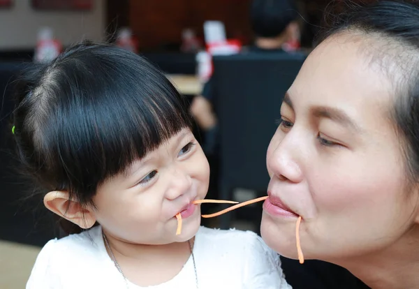 Drôle gamin fille manger carotte avec mère . — Photo