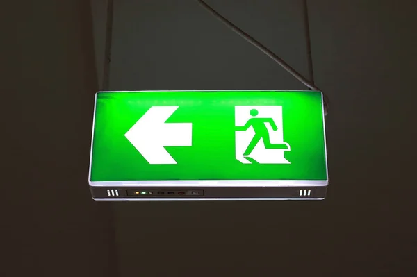green emergency exit sign in public building