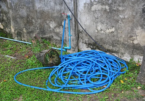 Rubber tube for watering plants in the garden,Rubber tube on grass in the garden — Stock Photo, Image