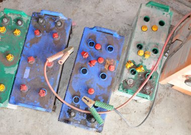 Bakır kelepçeli kırmızı ve siyah akü Jumper Kabloları olan bir araba aküsü